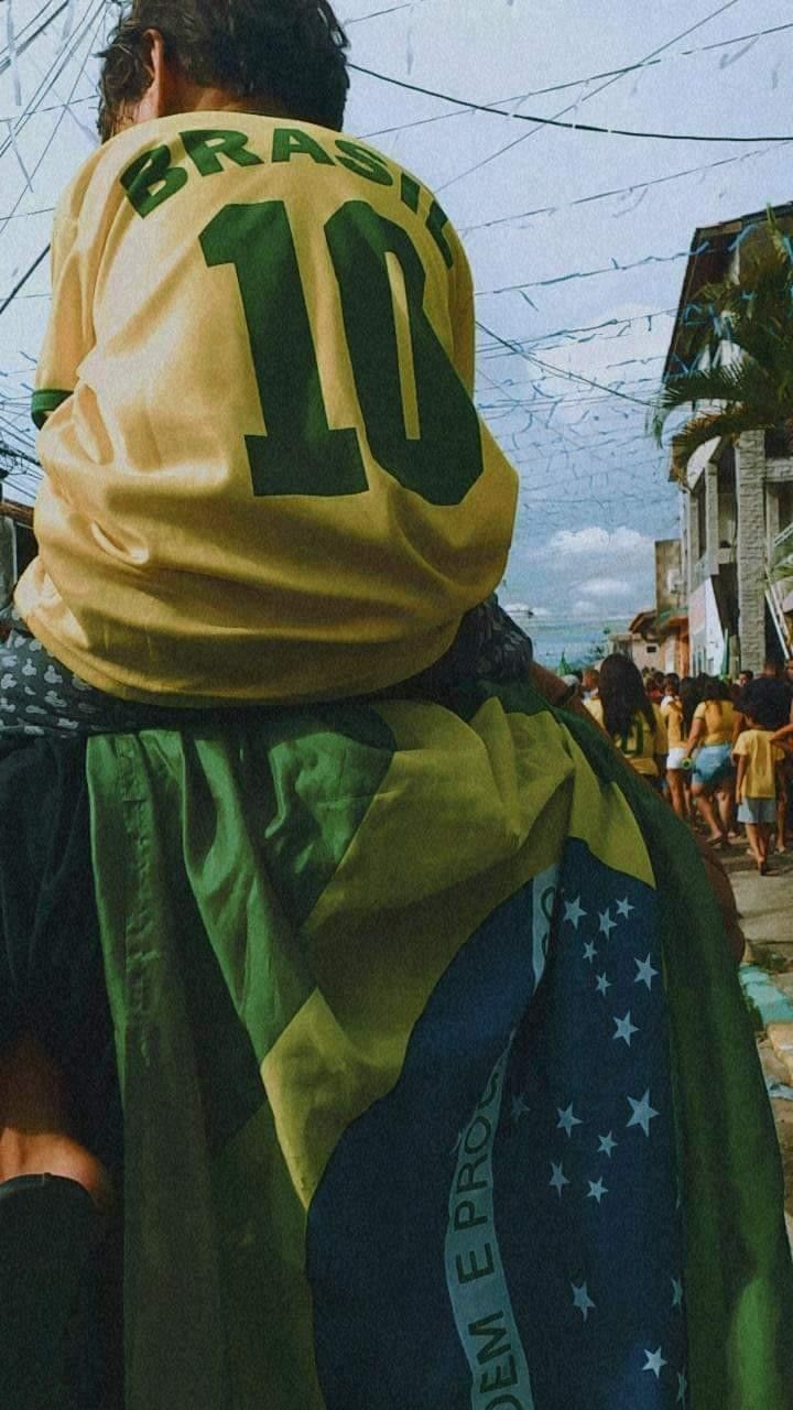 a man in a green and yellow jersey sitting on the back of a person wearing a cape