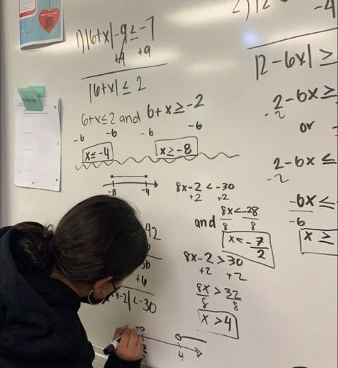 a woman writing on a white board with numbers