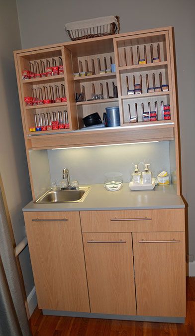 a kitchen area with sink, cupboards and counter top in the middle of it