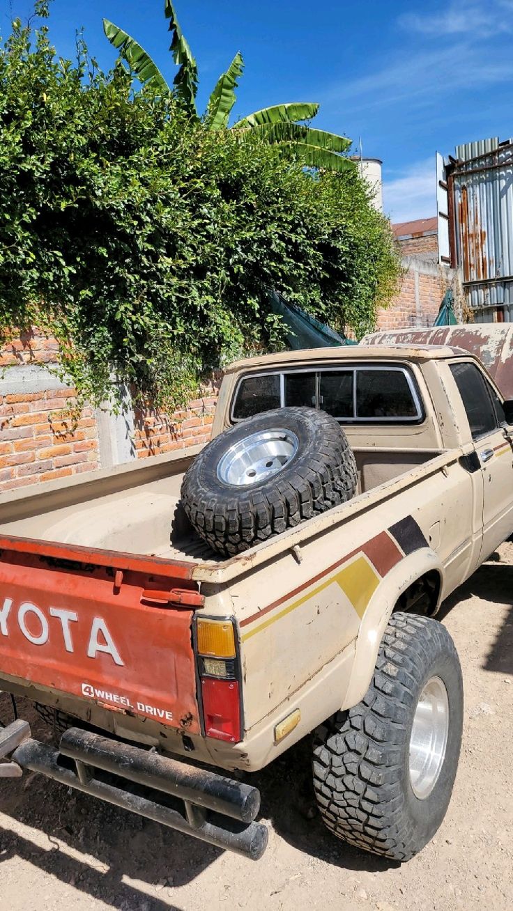 an old pick up truck with tires on the back