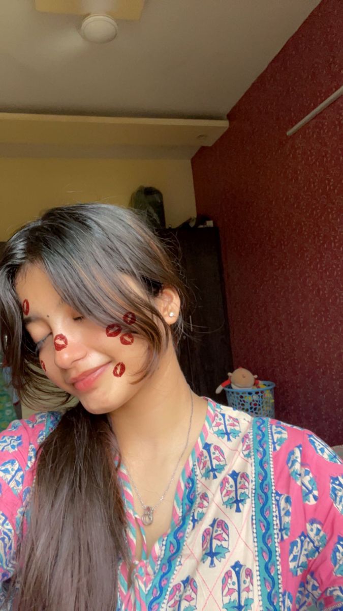 a woman with red paint on her face and long hair