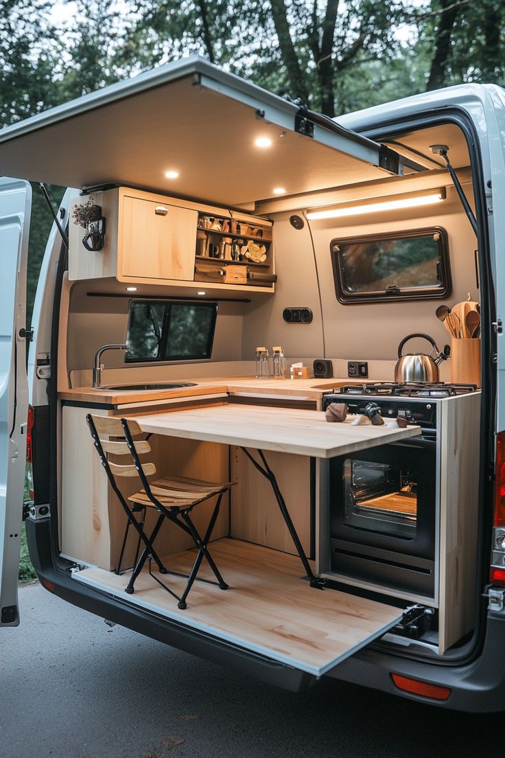 an open camper van with the kitchen and dining table in it's back