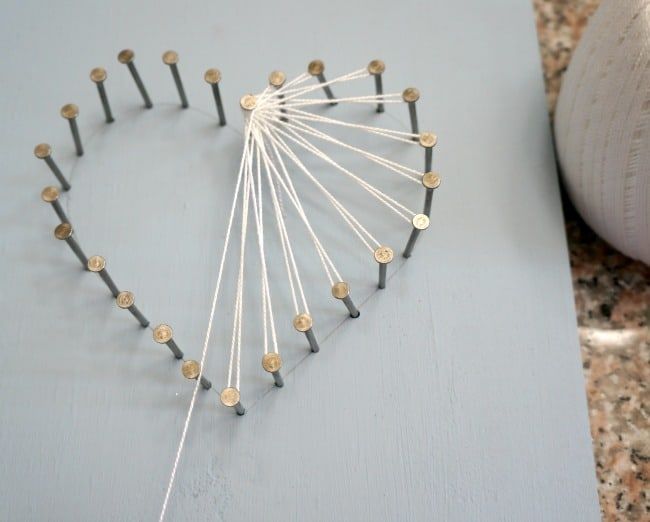 a heart made out of pins sitting on top of a table