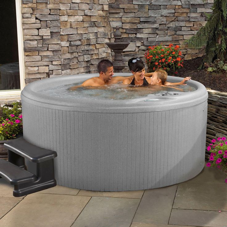 an outdoor hot tub with three people in it