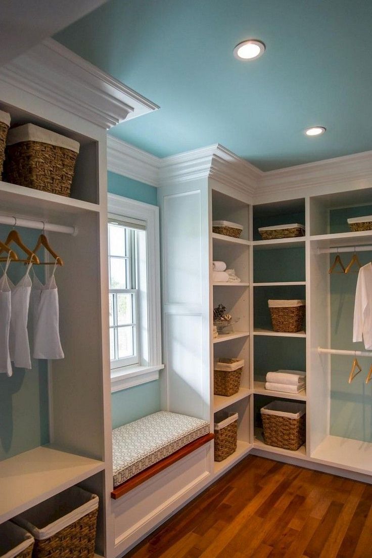 an empty walk - in closet with clothes hanging on the shelves and baskets under them