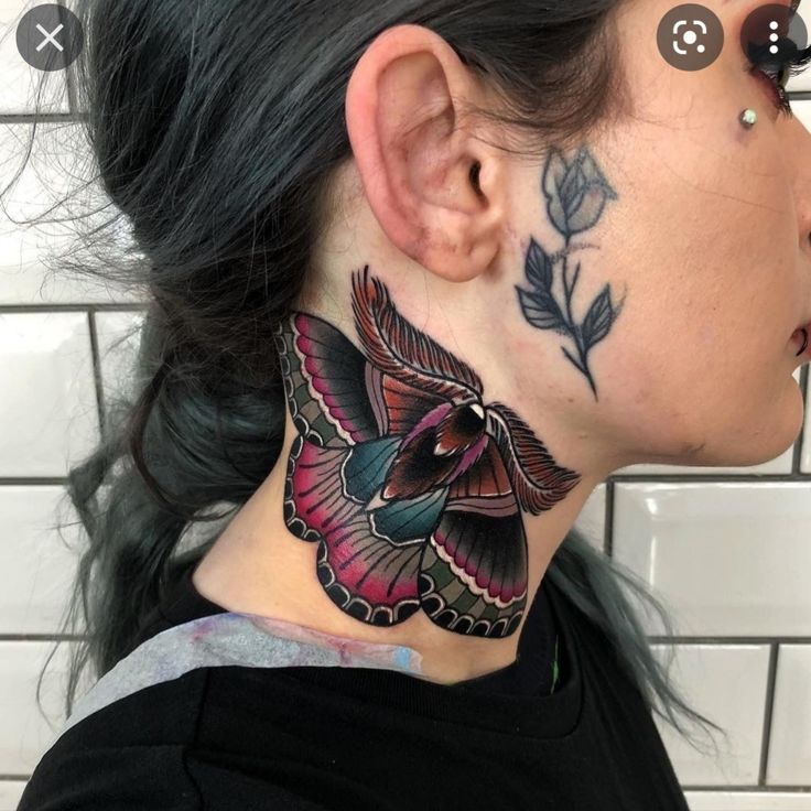 a woman with a butterfly tattoo on her neck