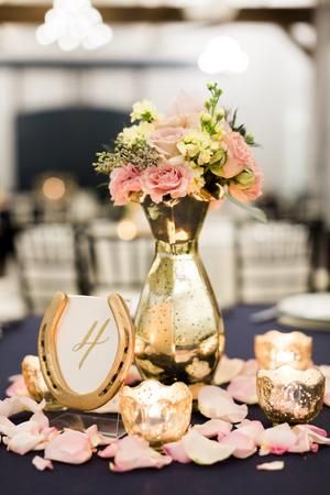 a vase with flowers and candles on a table in a banquet or wedding reception setting