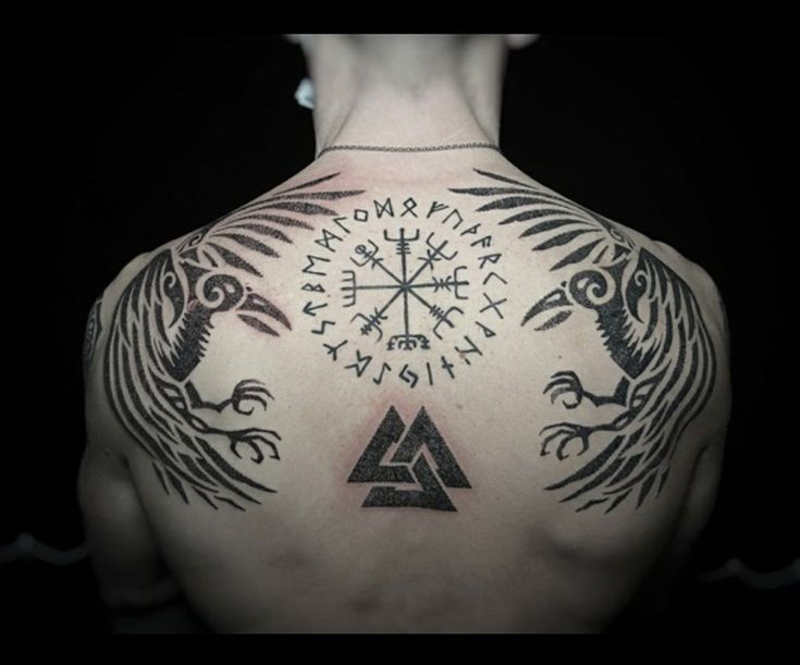 the back of a man with tattoos on his upper and lower half, which are decorated with symbols