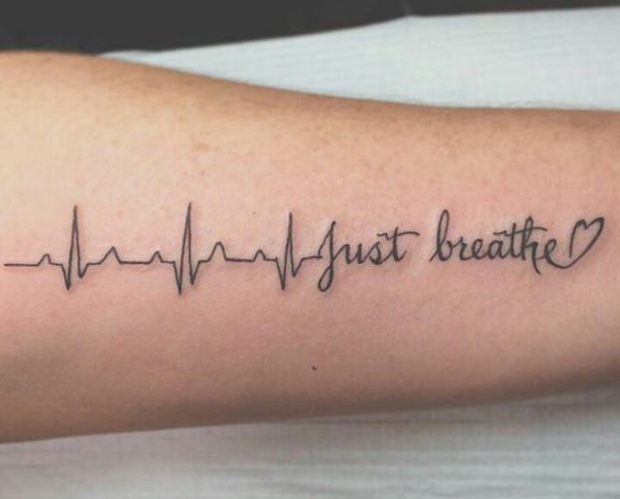 a person with a tattoo on their arm that says, just breathe and there is a heartbeat