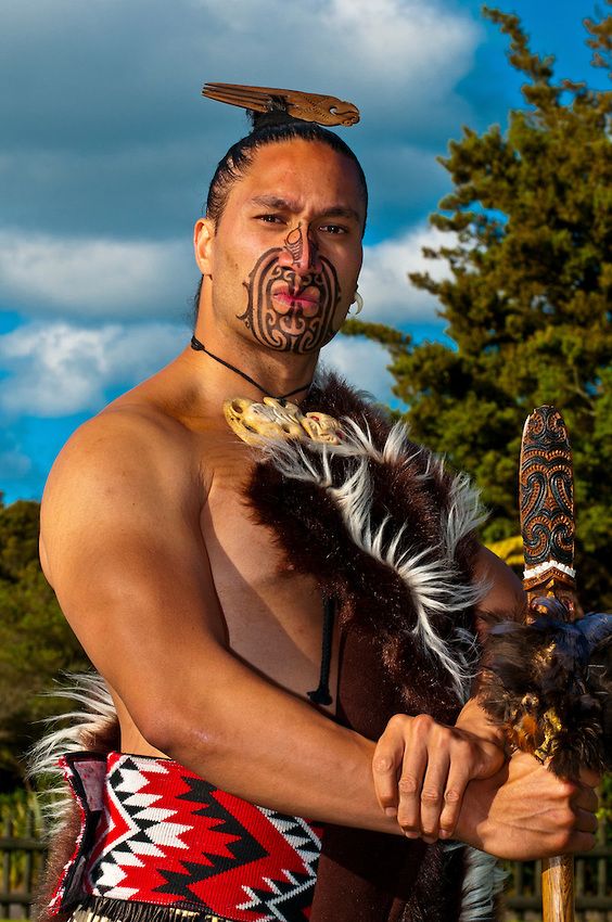 a man in native american clothing holding a stick