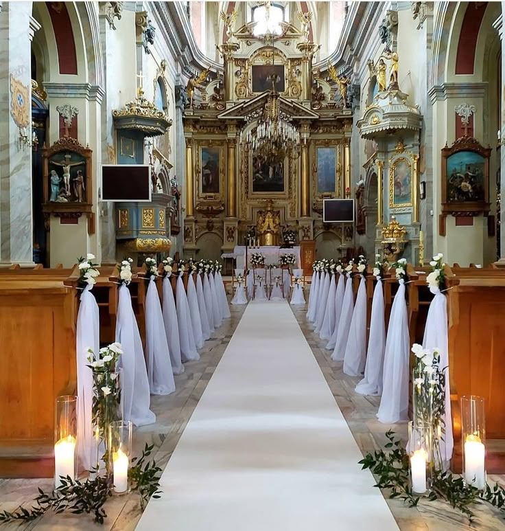 the aisle is decorated with white flowers and greenery as well as candles for the ceremony