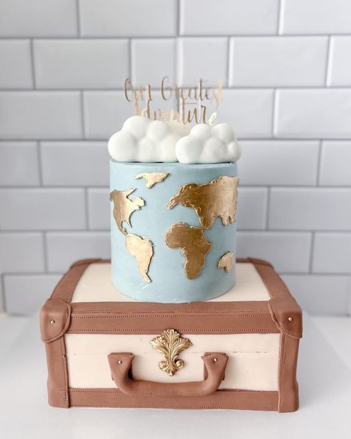 a cake that is sitting on top of a suitcase in the shape of a world map