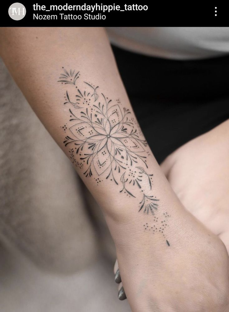 a woman's arm with a tattoo design on the left side of her wrist