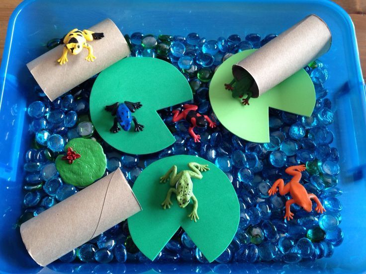 a blue plastic container filled with different types of toys and paper on top of it