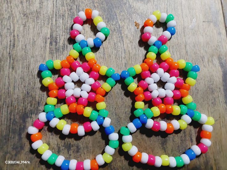 multicolored beaded earrings sitting on top of a wooden table