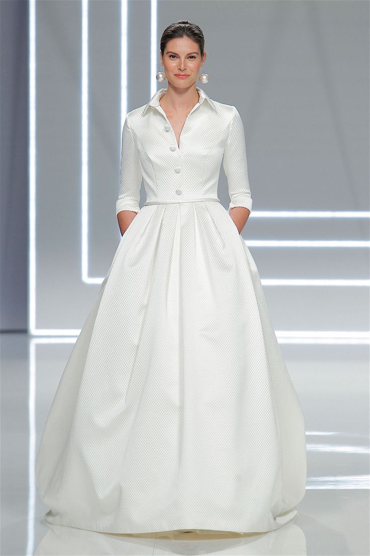 a woman in a white dress on the runway