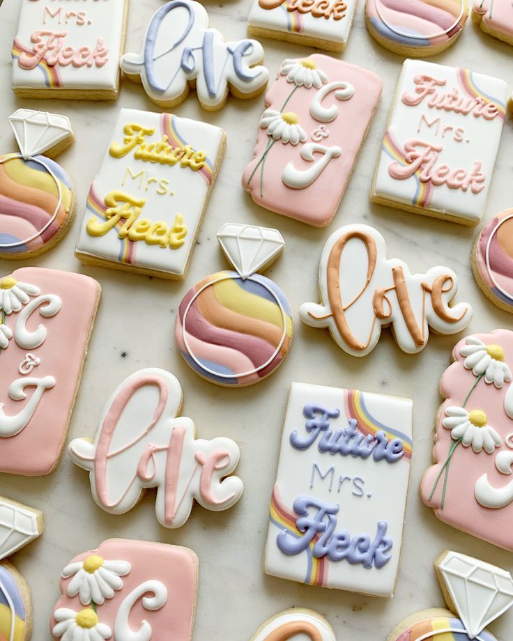 decorated cookies are arranged on a table with the words love spelled in white and pink