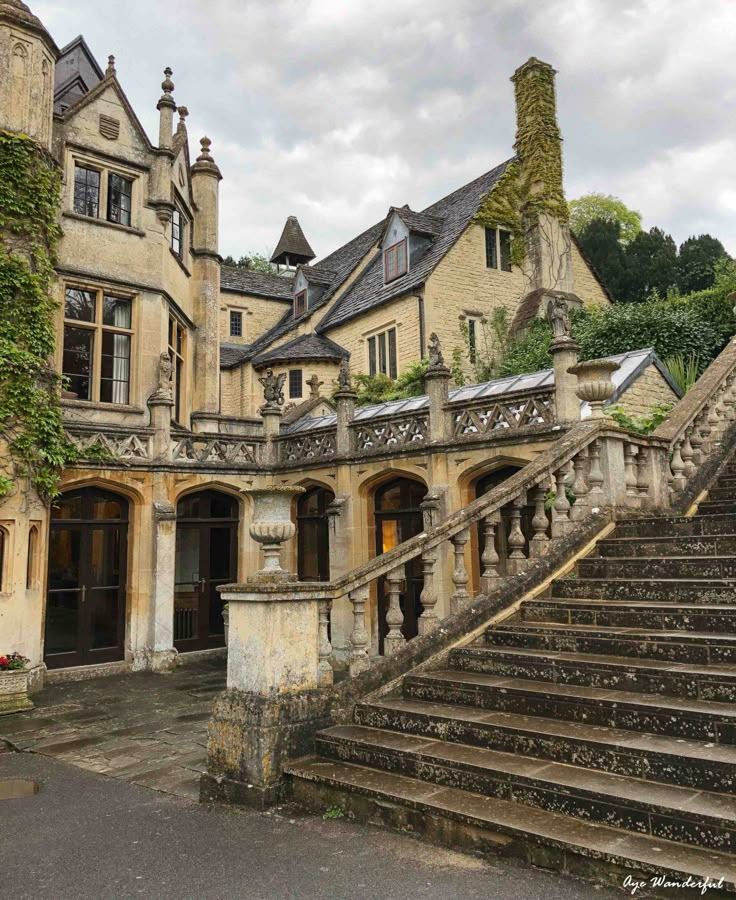 an old mansion with stone steps and ivy growing on the walls