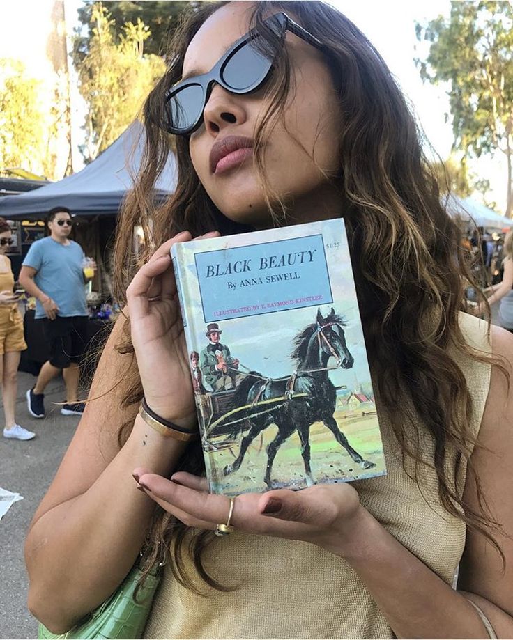 a woman holding up a book in front of her face