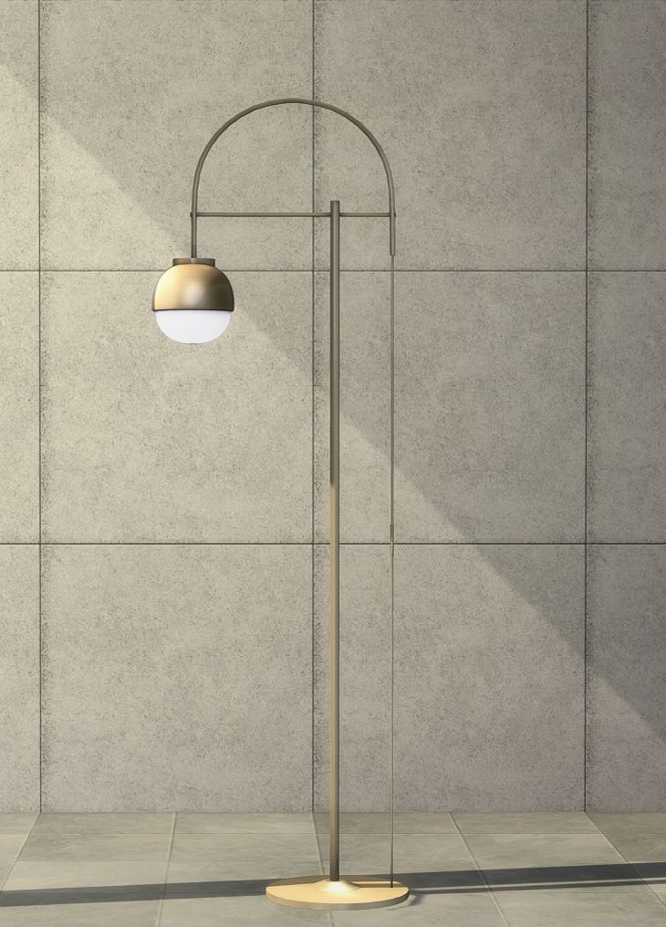 a floor lamp with a round light on it in front of a gray wall and tiled floor