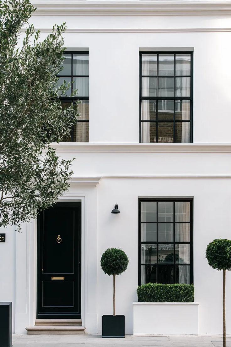 Minimalist white stucco house with striking black window frames and seamless indoor-outdoor connection White Exterior Black Windows, European Inspired Homes, White Two Story House, Farmhouse With Black Accents, White Building Exterior, Modern Stucco Exterior, Stucco Farmhouse, Grey Stucco House Exterior, European Contemporary Home