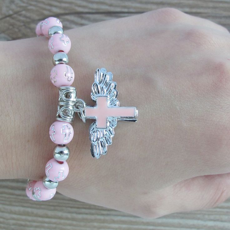 "12 PCS Wing of Angel gold or silver bracelets are absolutely stunning Favors for baptism, Christening, and any religious event. 12 Pcs PINK ANGEL CHARM BRACELET - A meaningful and useful favor for Baptism and religious events The Wings of angel adorn with beautiful enamel cross Stretchy bracelet fits youth and adult wrists. Wood bead size 8mm, Charm size: .75\" x 1\", fits youth & adult" Personalized Pink Spiritual Charm Bracelet, Personalized Pink Spiritual Bracelet, Personalized Pink Spiritual Bracelets, Spiritual Personalized Pink Bracelets, Spiritual Personalized Pink Bracelet, Spiritual Pink Personalized Bracelets, Adjustable Pink Cross Bracelet, Pink Adjustable Cross-shaped Bracelets, Spiritual Pink Beaded Hypoallergenic Bracelets