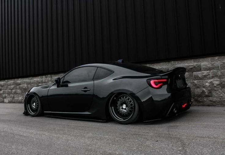 a black sports car parked in front of a building