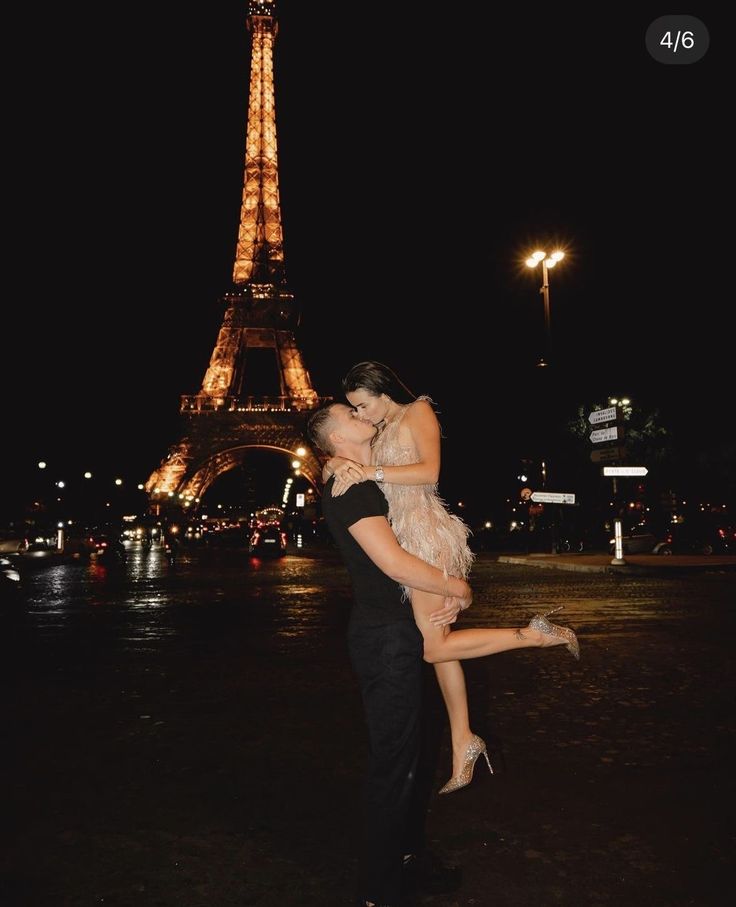 two people are hugging in front of the eiffel tower