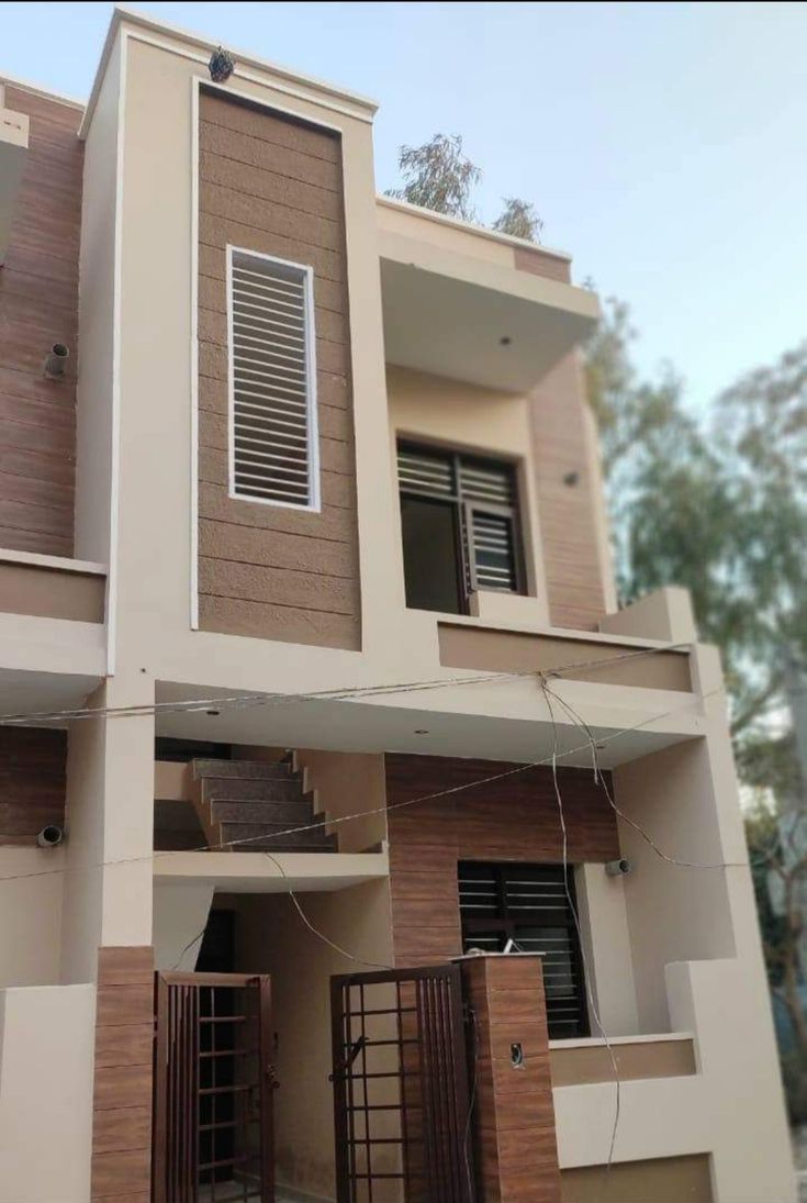 a two story house with brown and white walls