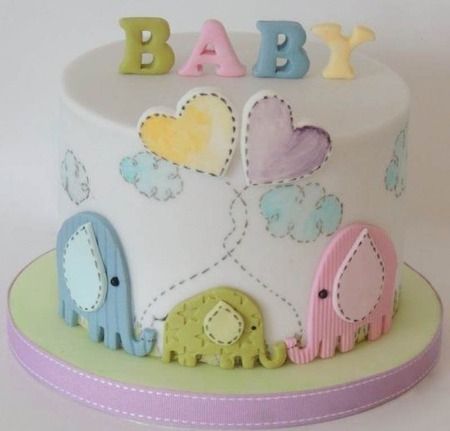 a baby cake with elephants and clouds on it's top is decorated in pastel colors