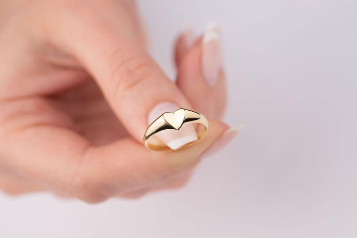 Our signet heart ring is 14k solid gold. Our gold heart ring has a unique style with looks like a folded heart. It fits your all outfit and becomes your everyday ring. When you think of our 14k gold heart ring as a gift, it is a product that will make your loved ones happy on their birthday, Valentine's day, Mother's day, anniversaries, graduations, Christmas gift or other special days. Also, it can be a perfect gift for yourself. :) 🎁 If you want, you can add a gift note for your loved ones. It arrives in a special jewelry gift box. ✨ We respond to your questions happily. Your question will be answered within 24 hours. Do not hesitate to contact us. 💎 I hope you have a lot of Onseva's designs. :) a.b.-G Simple Gold Heart Ring For Valentine's Day, Simple Gold Heart Ring Gift, Simple Gold Heart Ring As Gift, Minimalist Heart Shaped Signet Ring For Promise, Minimalist Heart Shaped Signet Promise Ring, Heart Shaped 14k Gold Signet Ring For Gift, 14k Gold Heart-shaped Signet Ring Gift, Simple Gold Heart Ring, Heart-shaped 14k Gold Signet Ring As Gift