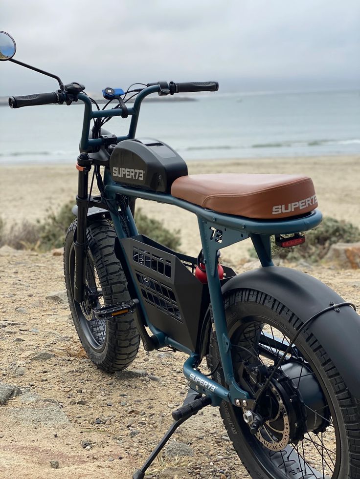 a motorcycle parked on top of a sandy beach