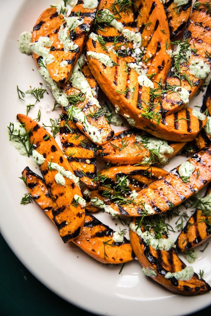 grilled sweet potato wedges with blue cheese and dill dressing on a white plate