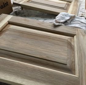 a close up of a wooden cabinet door with some cloth on the floor next to it