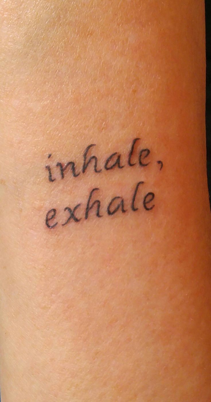 a tattoo saying inhale, exhale on someone's arm