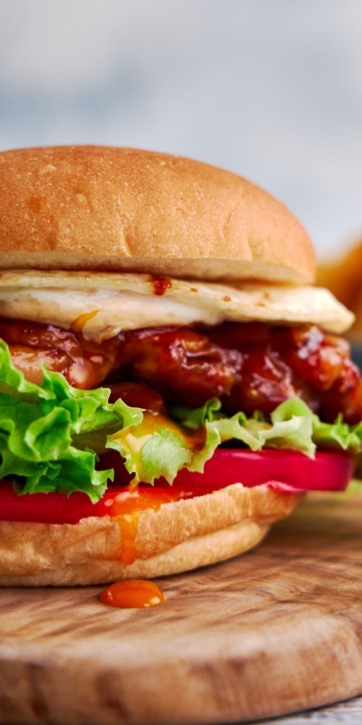 a bacon and lettuce sandwich sitting on top of a wooden cutting board