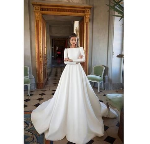 a woman in a white wedding dress posing for the camera