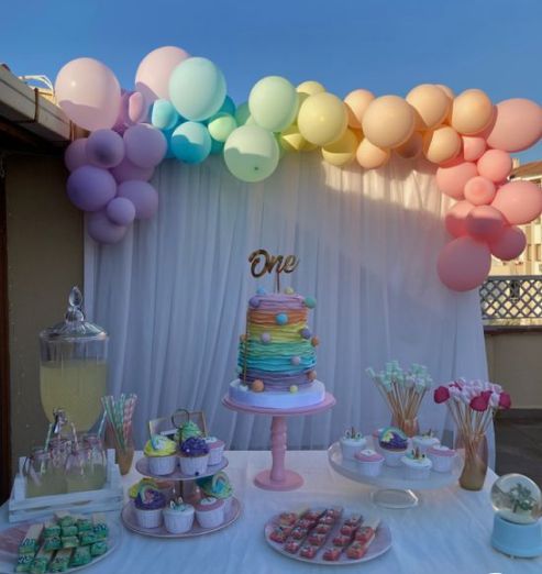 a table topped with lots of cake and balloons