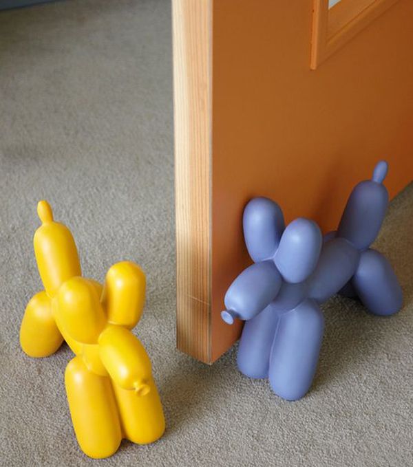 two small plastic toys sitting on the floor next to an open door, one yellow and one blue