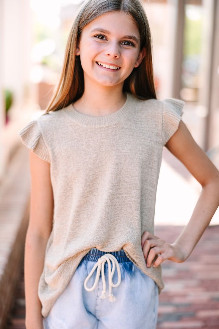 You are certainly going to be happy in this top! And best of all, so will your daughter! That knit fabric is so cute and we adore those girly ruffled sleeves! This neutral colored top is going to look so good with white or blue jeans and will honestly take your girl from season to season! This top features a round neckline, ruffled cap sleeves, and a knit fabric. Material has a generous amount of stretch.Addison is wearing the large. Floral Cocktail Dress, Black Tie Dress, Long Sleeve Outerwear, Two Piece Swimwear, Friend Outfits, Your Girl, Ruffled Sleeves, Romper With Skirt, To Be Happy