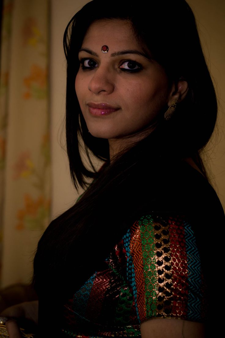 a woman in a colorful sari posing for the camera with her eyes wide open