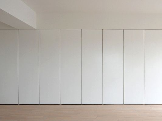 an empty room with white walls and wood floors