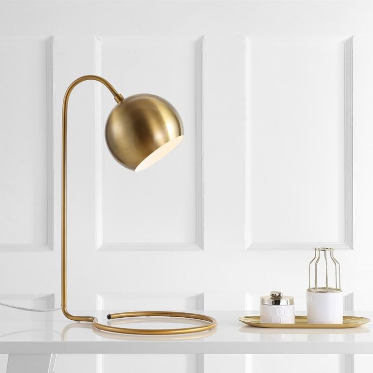 a desk lamp sitting on top of a white table next to a mirror and other items