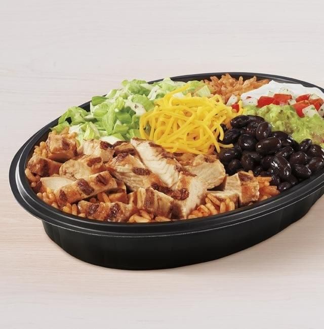 a salad with chicken, lettuce, black beans and cheese in a bowl