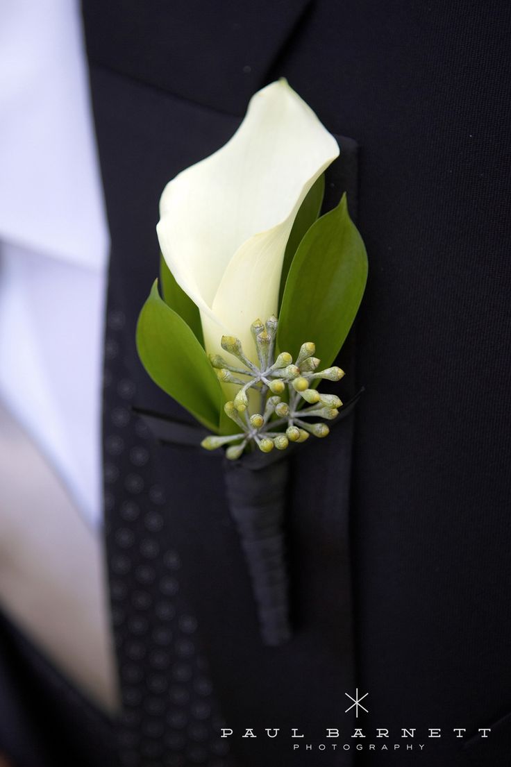 a boutonniere with white and green flowers on it's lapel