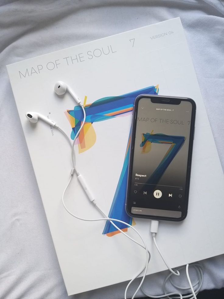 an mp3 player and headphones laying on top of a map of the soul 7