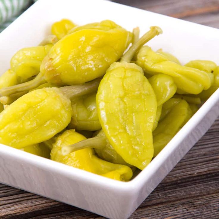 a small white bowl filled with green peppers