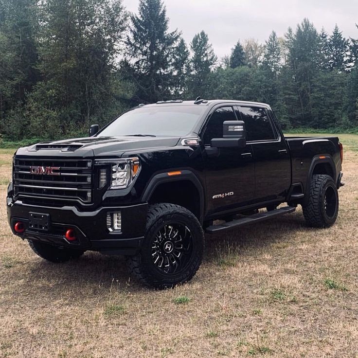 a large black truck parked in the middle of a field