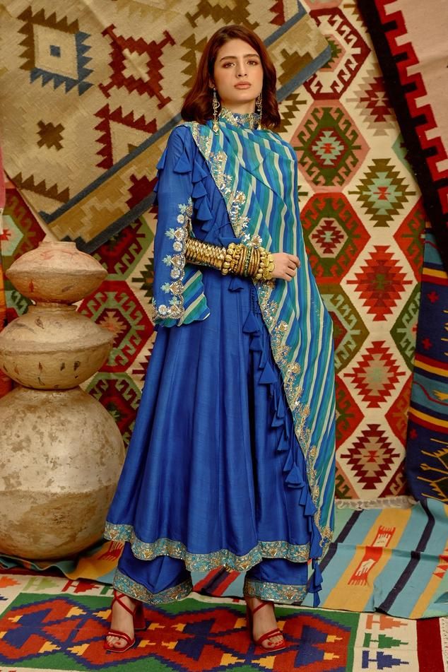 Cobalt blue anarkali with detailed slit sleeve embroidered in resham gota patti. Comes with dori tassel blue indi-leheriya dupatta and pant.
Components: 3
Pattern: Embroidered
Type Of Work: Resham gota patti and dori tassel
Neckline: Scoop
Sleeve Type: Split Sleeves
Fabric: Kurta and pant- Tussar, Dupatta- wrinkle crepe, Lining- Mulmul
Color: Blue
Other Details: 
Scalloped sleeves
Tasselled dupatta
Pant closure- side zip
Note: Blue and pink sharara sets worn by the other two models in the video Royal Blue Indian Dress, Sleeves Pattern For Kurtis, Trousseau Outfits, Blue Indian Dress, Leheriya Dupatta, Embroidered Outfit, Gota Patti Suits, Pink Sharara, Scalloped Sleeves