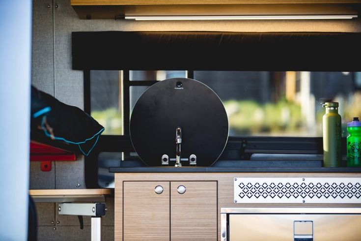 a kitchen area with a stove, sink and oven in the back ground next to a window